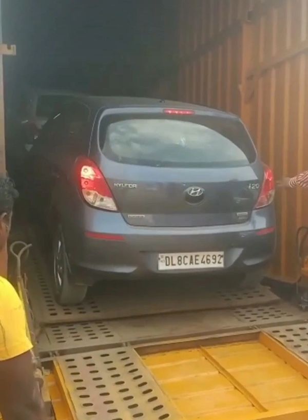 A Hyundai i20 car being loaded into a container on a ramp.