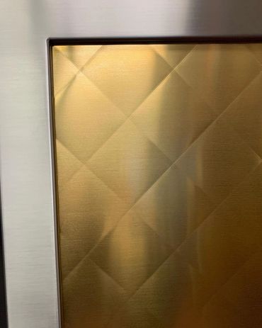 Backsplash with stainless and quilted brass. 