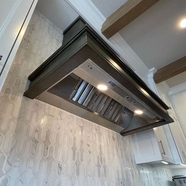 Custom steel kitchen hood with patina finish and clear lacquer. Sweeping body style with half round 