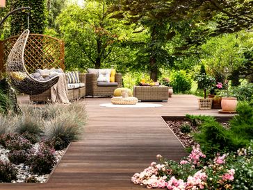 A house garden with a wooden deck, with garden furniture