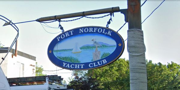 Sign for Port Norfolk Yacht Club hanging from a pole.