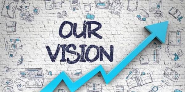 Blue arrow pointing up with 'OUR VISION' text on a brick wall.