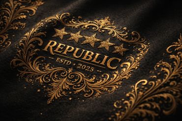 Elegant golden emblem reading 'REPUBLIC ESTD 2025' with ornate floral designs on black fabric.