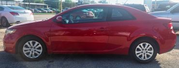 Red two-door coupe parked outdoors.