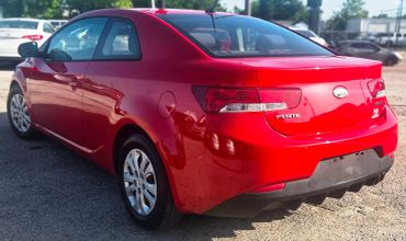 Red Kia Forte parked outdoors.