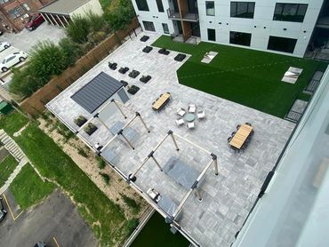 Modern rooftop patio with seating, greenery, and recreational areas.