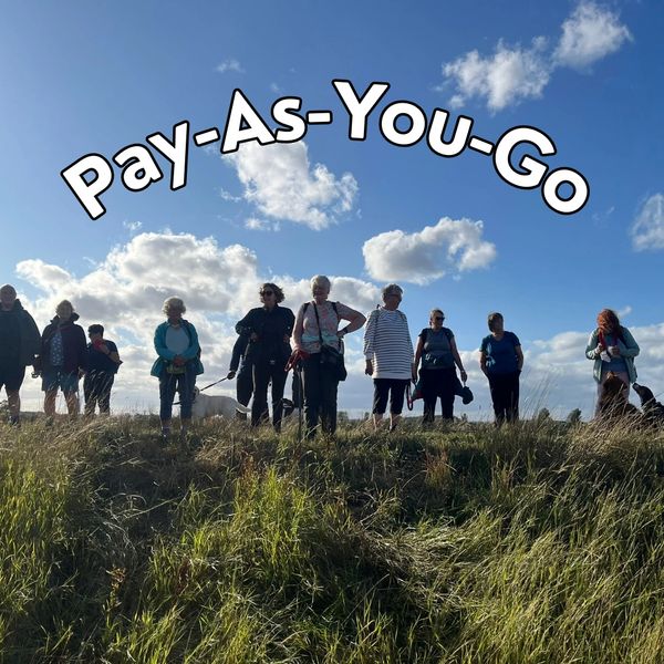 A group of people walking outdoors under a blue sky with clouds.