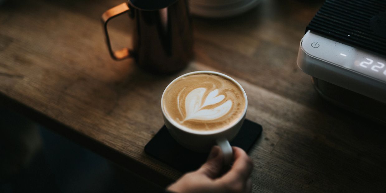 A cup of latte art at a coffee counter.