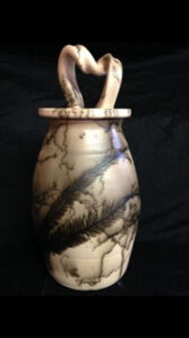 Artistic ceramic vase with a heart-shaped handle and unique black patterns.