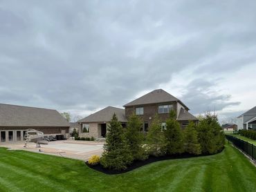 Spacious backyard with a pool, slide, and neatly trimmed lawn.
