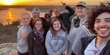 Un groupe de volontaires heureux admirant le coucher du soleil