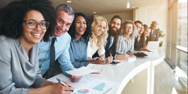 Une équipe diverse et souriante en réunion professionnelle.