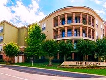 Modern residential building with balconies and trees.