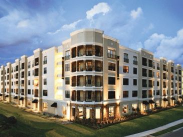 Modern apartment building illuminated at dusk.