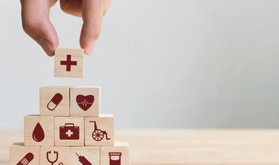 Hand Holding Wooden Blocks With Medical Icons on Them