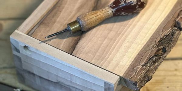 Handmade wooden gift box with a hand tool on it