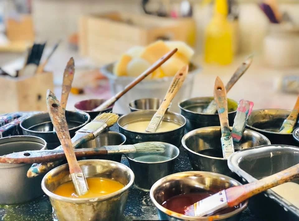 pots of encaustic paint on a griddle.  Encaustic medium and tools can be seen in the background.