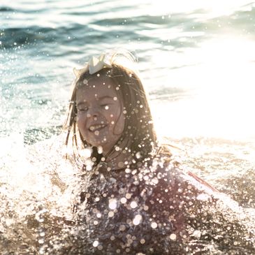 Young girls swimming, splashing in the water. Life style Photography image, Portage Point Onekama MI