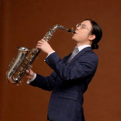Man in suit playing saxophone.