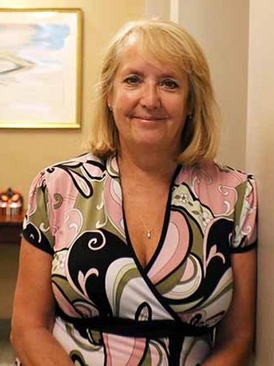 Kelly James smiling and leaning on a wall