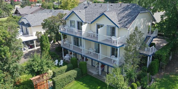 Three-story house with balconies and garden.