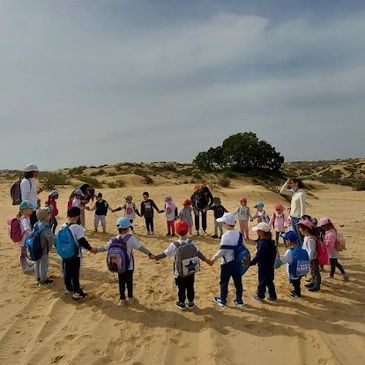 Children holding hands in the sand dunes of Ashdod