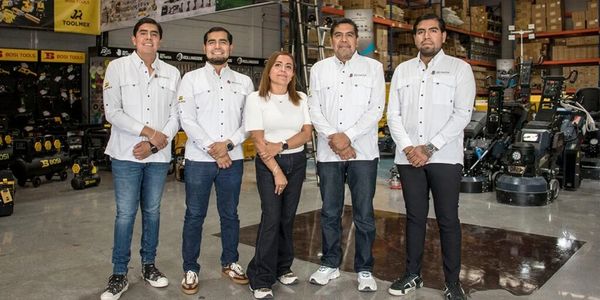 Equipo de cinco personas en un almacén de herramientas industriales.