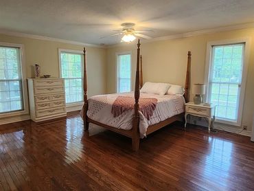 Bedroom with hardwood floors and wooden bed.