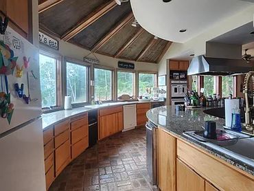 Bright kitchen with curved counters and windows.