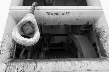Close-up of a towing wire on a rusted metal surface.