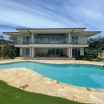 Modern two-story house with a large swimming pool and patio area.