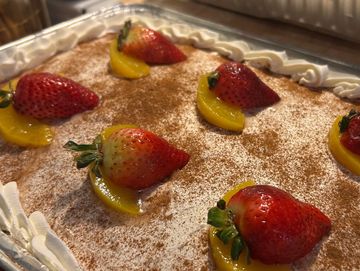 Dessert topped with strawberries and peach slices.