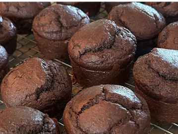 Freshly baked chocolate muffins cooling on a rack.