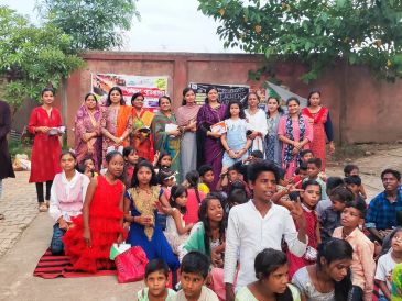 Group of women and children gathered outdoors.