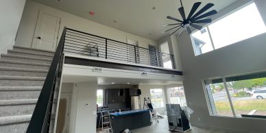 Modern loft-style living room with high ceilings and large windows.