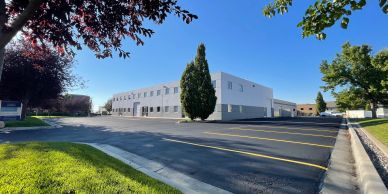 A commercial building with a parking lot on a sunny day.