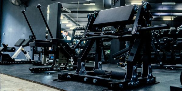 Black gym equipment set on a rubber mat in a modern gym.