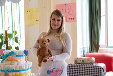 Pregnant Woman Holding a stuffed teddy bear at her baby shower, heartbeat animal