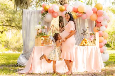 Daughter is kissing her mom's pregnant belly at a baby shower