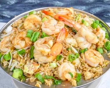 A bowl of shrimp fried rice garnished with green onions.