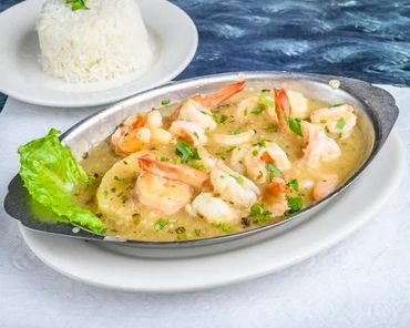 Shrimp cooked in a creamy garlic sauce with lettuce and white rice.