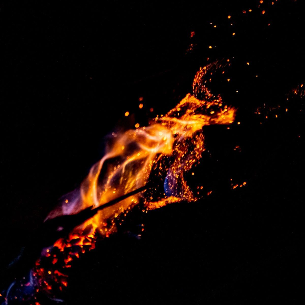 Bright orange flames and sparks against a black background.