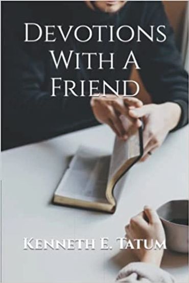 A man sitting at a table opening the book Devotions With A Friend.