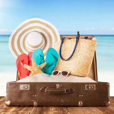 Open suitcase on a tropical beach, symbolizing the final step of trip preparation with Travel-Mingo.