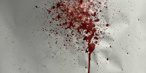 Red splattered liquid on white background.