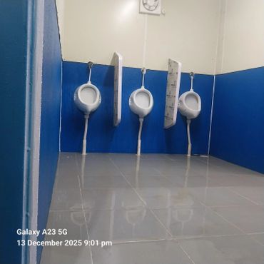Three urinals with blue and white walls in a clean restroom.