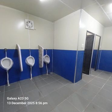 Clean restroom with blue and white walls, urinals, and stalls.