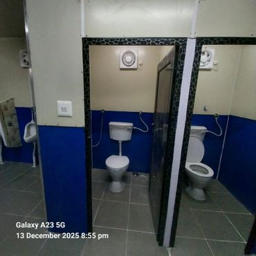Two toilet cubicles and a urinal in a clean public restroom.