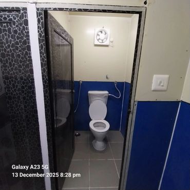 Small, clean bathroom with blue walls and white toilet.