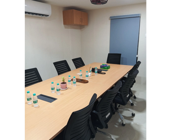 A modern conference room with black chairs and a wooden table.